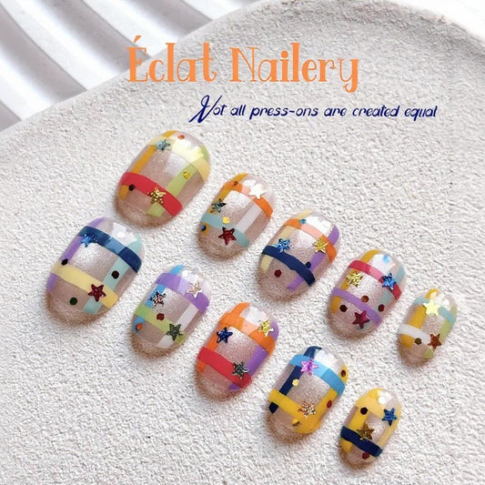 Handmade press-on nails featuring colorful rainbow grid patterns with a glossy finish, designed for playful, bold expression.