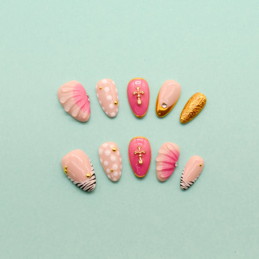 Almond press-on nails with zebra stripes, pink 3D shells, polka dots, gold cross embellishments, and chrome gold tip – Electric Pop Royale set.