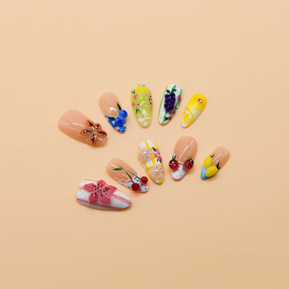 Medium Almond press-on nails featuring cherries, lemons, grapes, and floral embellishments in a colorful fruity design – Fruit Garden Bloom nail set.