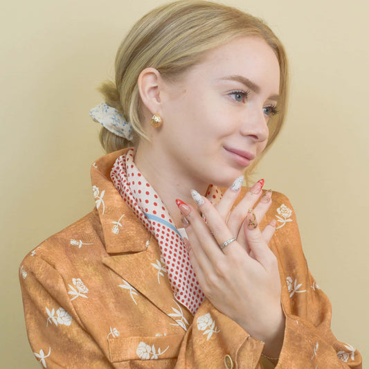 Gingerbread Joy press-on nails featuring gingerbread men, candy canes, holly leaves, and snowflakes on red and nude bases.