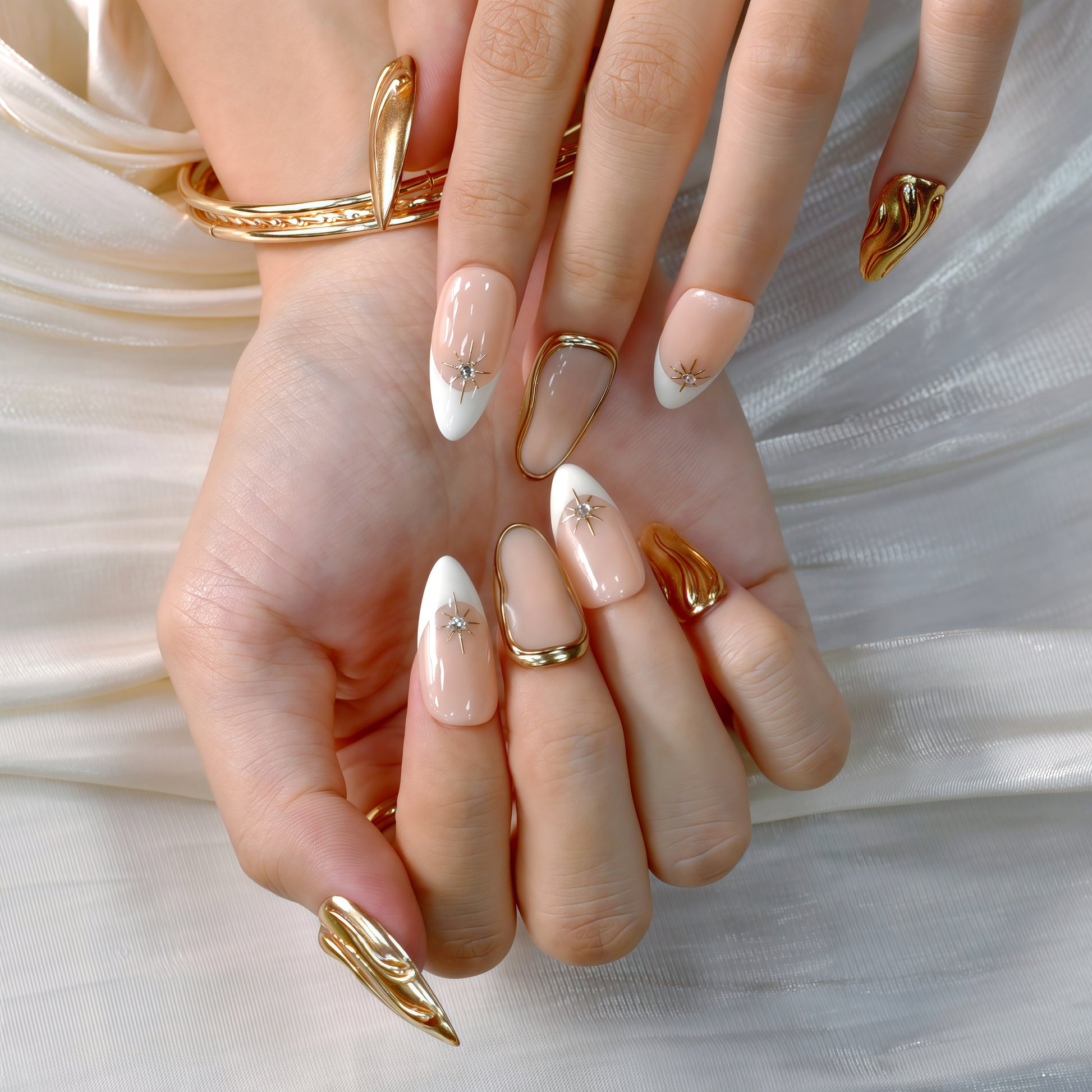 Luxury nude and white French tip press-on nails with gold chrome accents and star gem details displayed on a soft white background