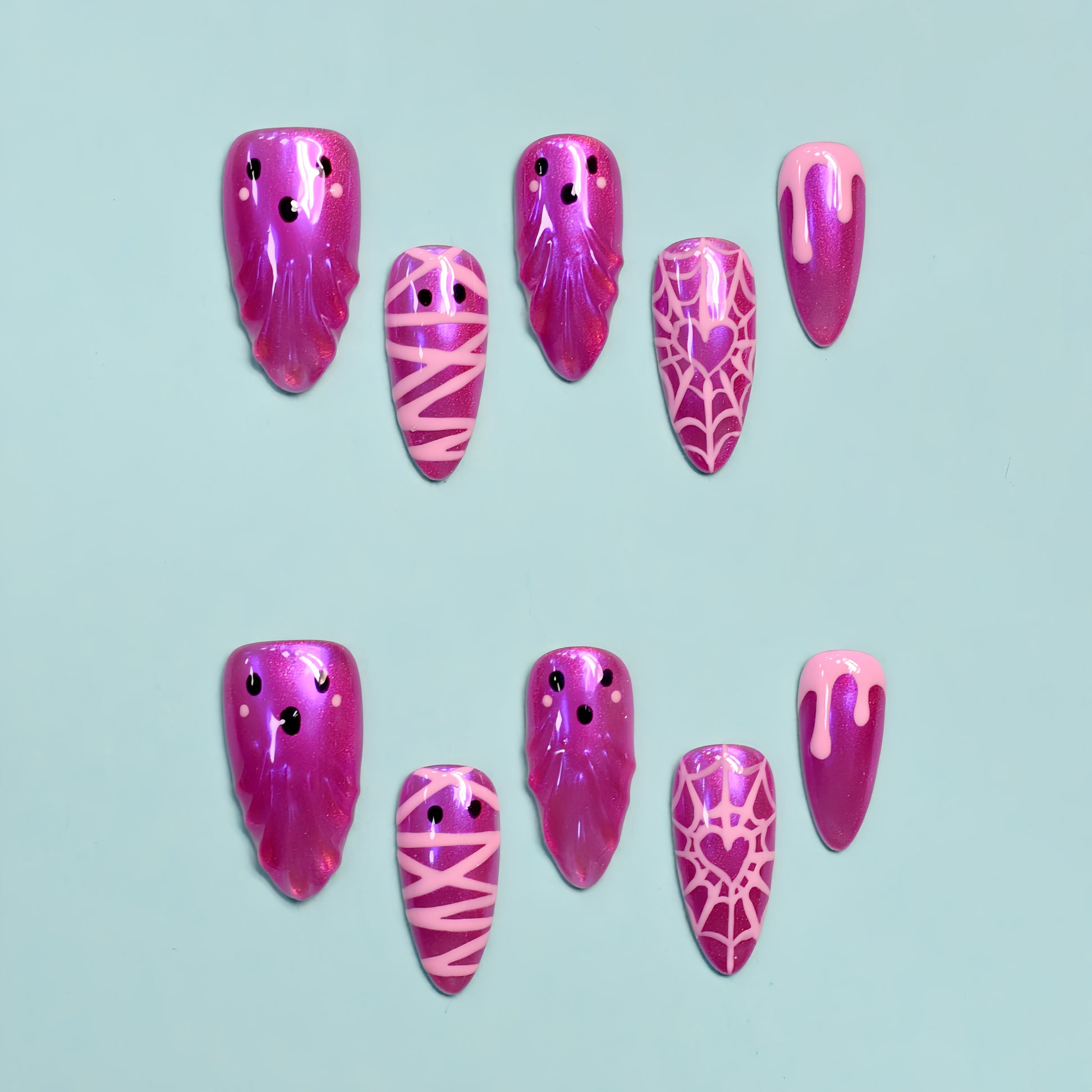 Pink Halloween press-on nails with ghosts, spider webs, and mummy wrap design.