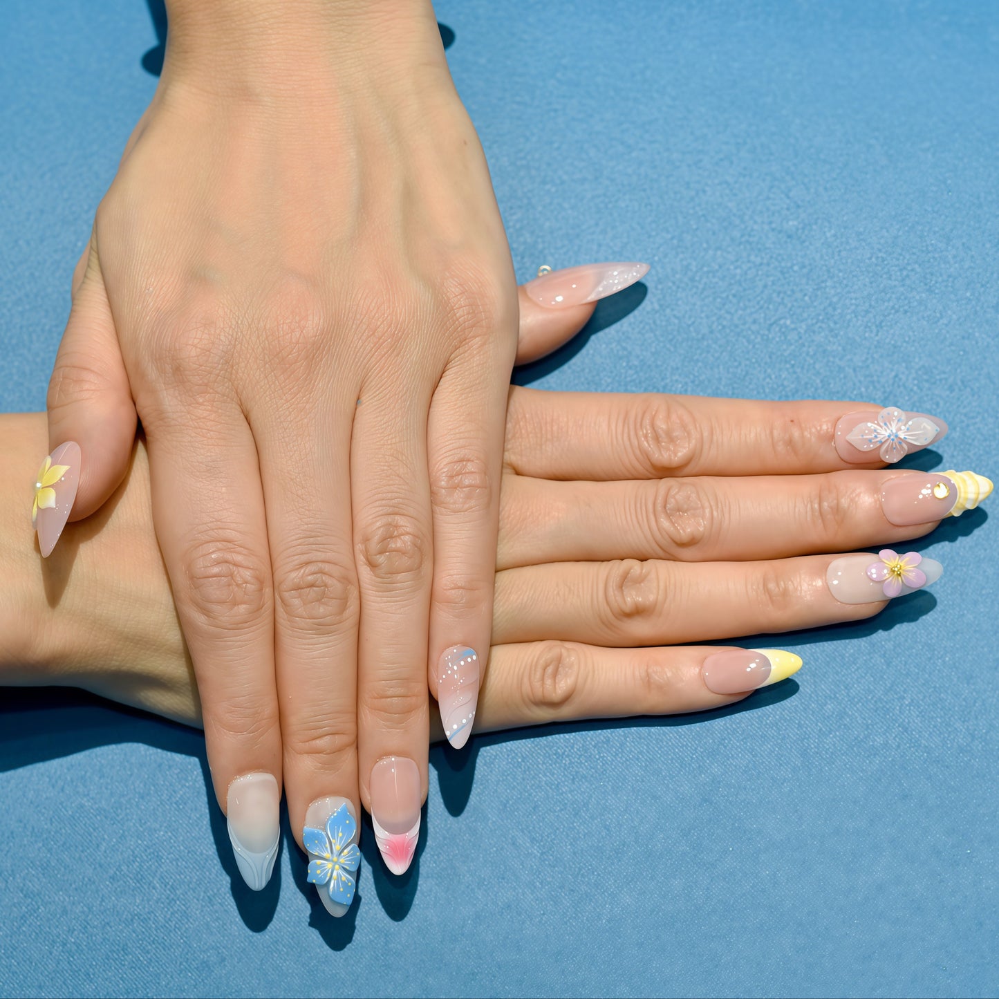 Tropical press on nails with nude base, bright 3D flowers in yellow, blue, and purple – Tropical Bloom Collection.