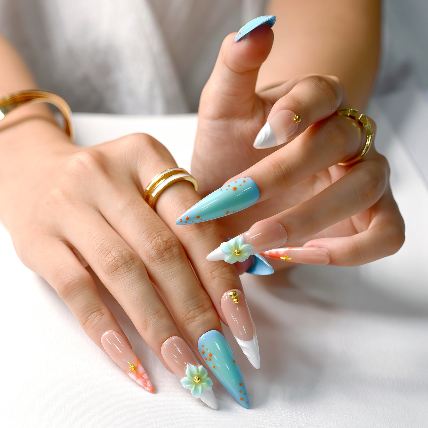 Tropical-themed stiletto press-on nails with aqua-blue gradient, 3D flowers, and orange coral accents – Island Bloom by You Are Angel.
