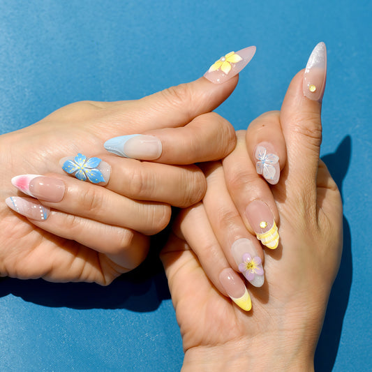 Tropical press on nails with nude base, bright 3D flowers in yellow, blue, and purple – Tropical Bloom Collection.