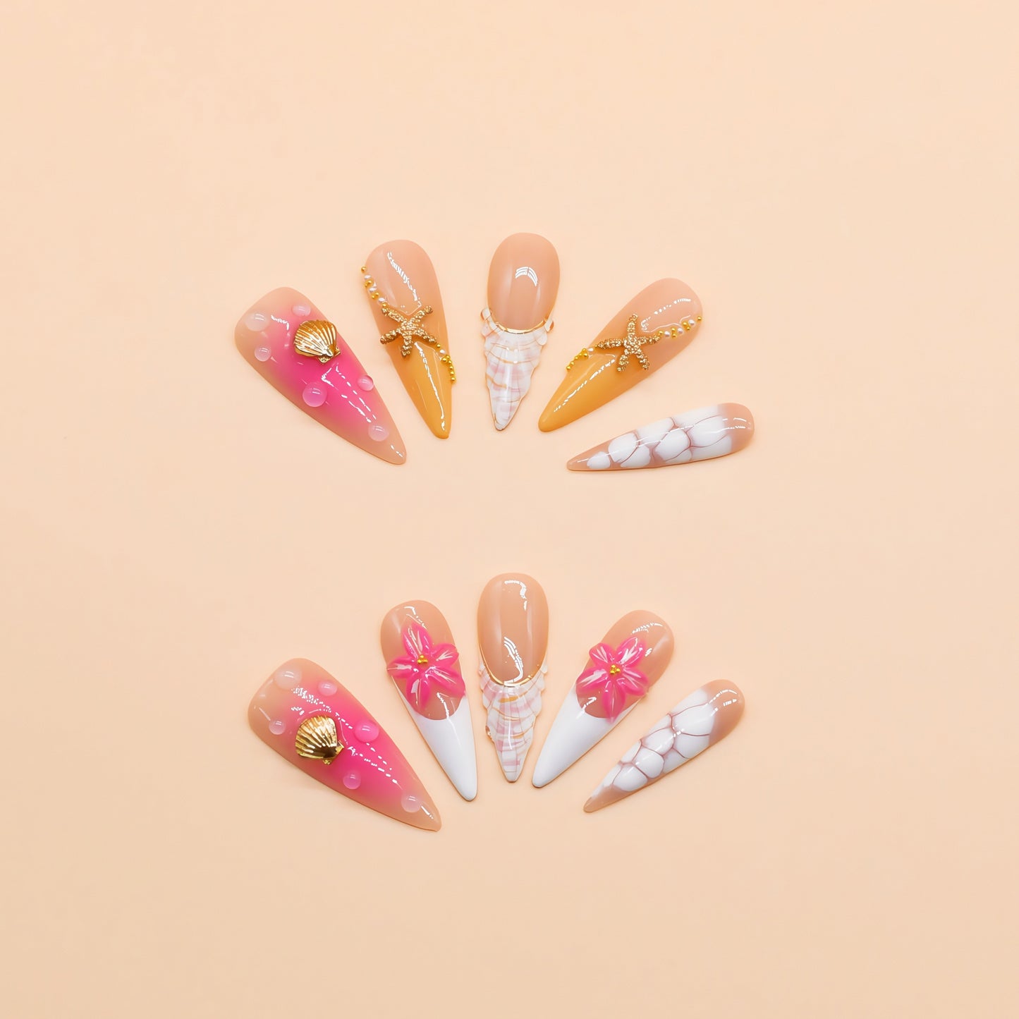 Long stiletto tropical press-on nails featuring vibrant pink and orange gradients, 3D starfish and gold seashell accents – Island Glow nail set.