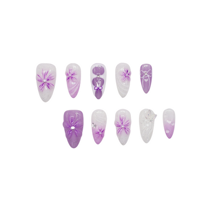 Lilac ombre glitter press on nails with 3D flowers, pearl centers, and bow accents – medium almond shape from Candy Bloom Collection.