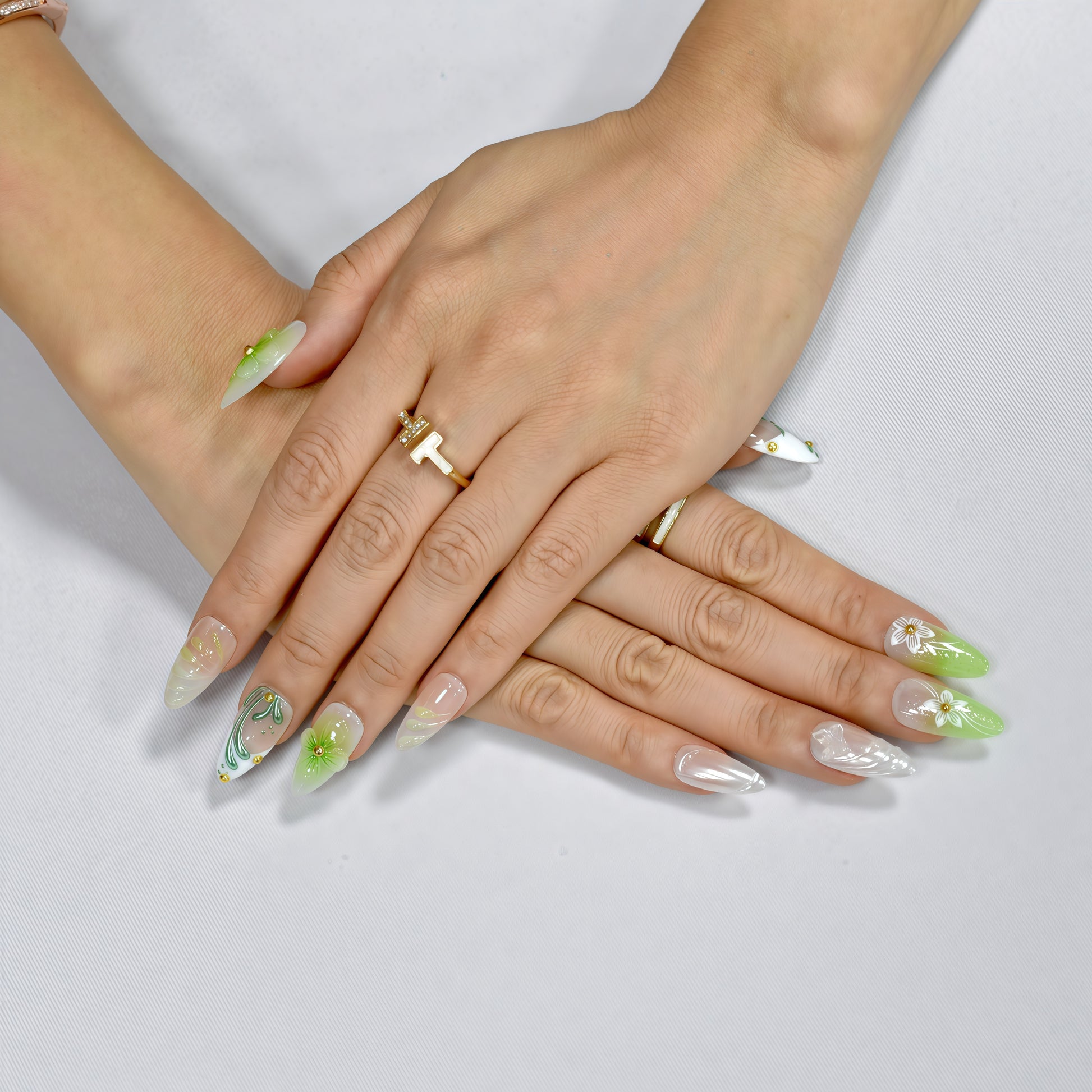 Green and white floral press-on nails with 3D blossoms, leaf detailing, and gold embellishments – handmade by You Are Angel.