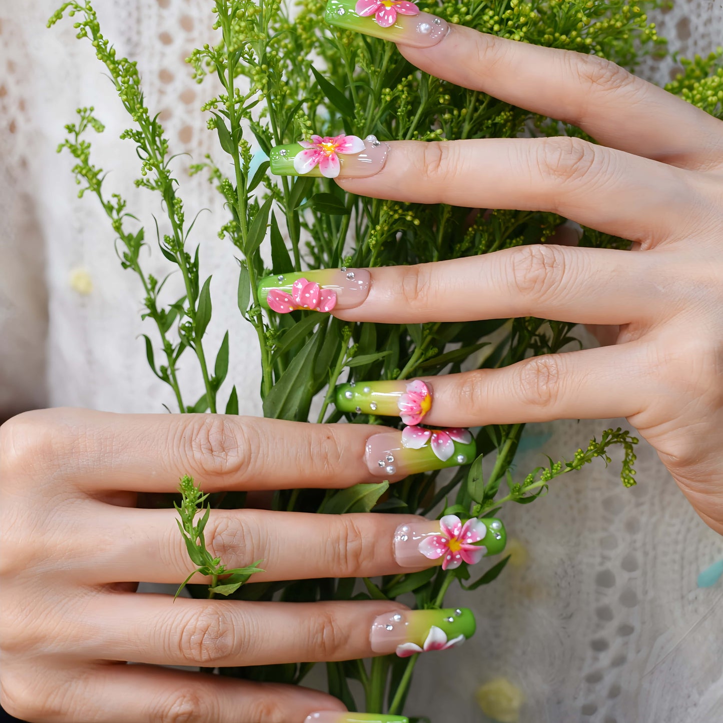 Handmade lime green floral press-on nails with 3D pink flowers and rhinestone accents on long square glossy nails