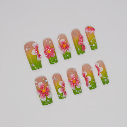 Handmade lime green floral press-on nails with 3D pink flowers and rhinestone accents on long square glossy nails
