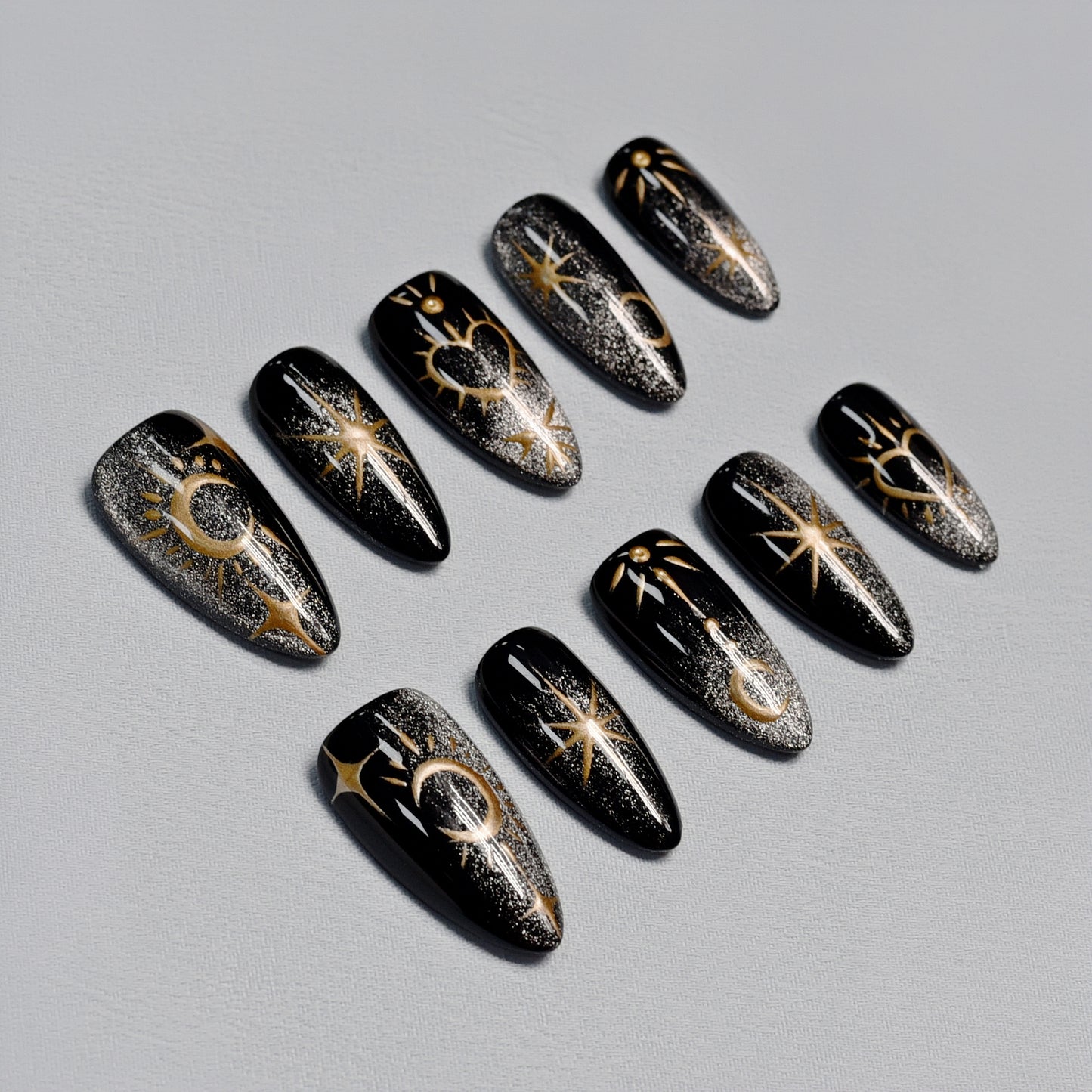 Moonlight Ritual handmade press-on nails by You Are Angel featuring black base with gold celestial art including moons, stars, and hearts.
