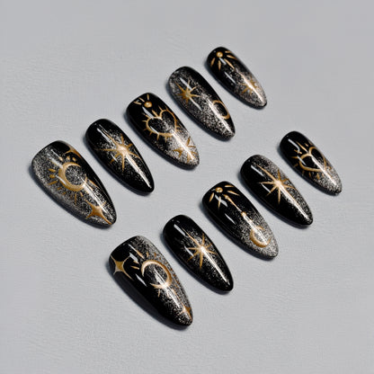 Moonlight Ritual handmade press-on nails by You Are Angel featuring black base with gold celestial art including moons, stars, and hearts.