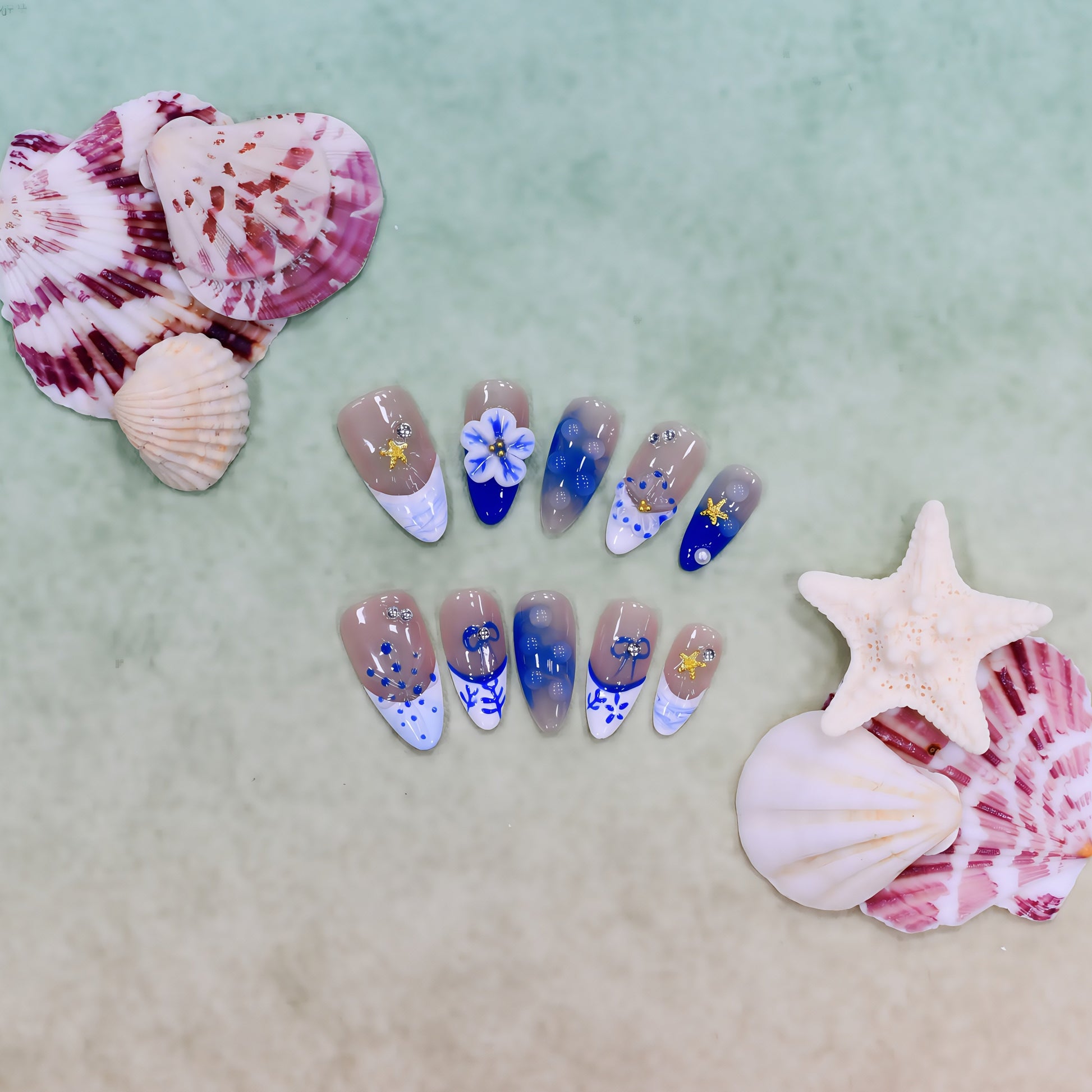 Handmade medium-length coffin press-on nails in ocean blue tones with 3D floral, coral, and starfish designs – Ocean Whimsy set.