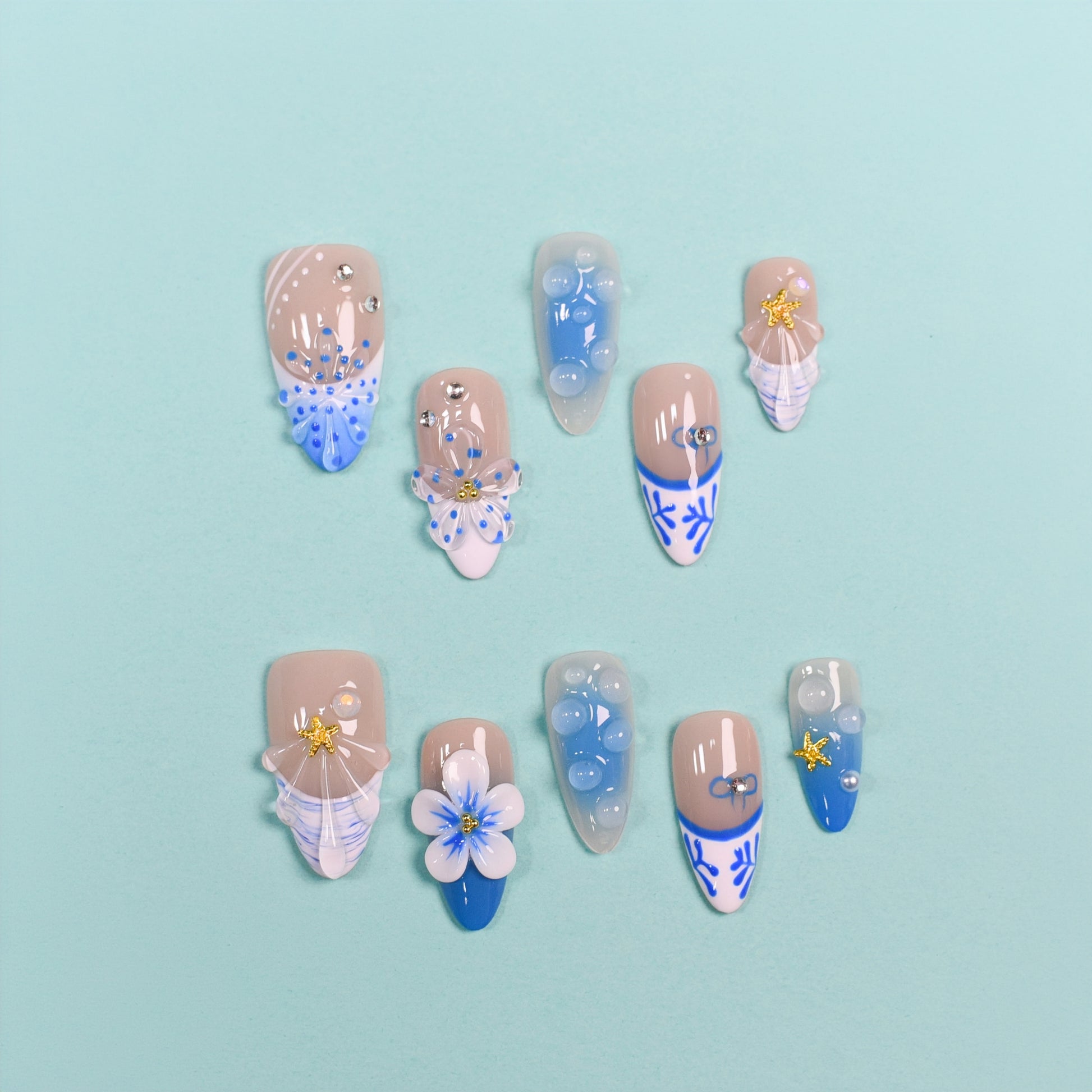 Set of decorative nails with floral and abstract designs on a light blue background