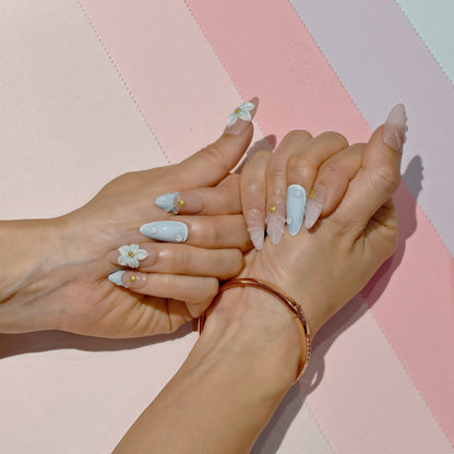 Pastel blue and pink press on nails with 3D floral accents, gold beads, and almond shape – Tropical Bloom Collection.