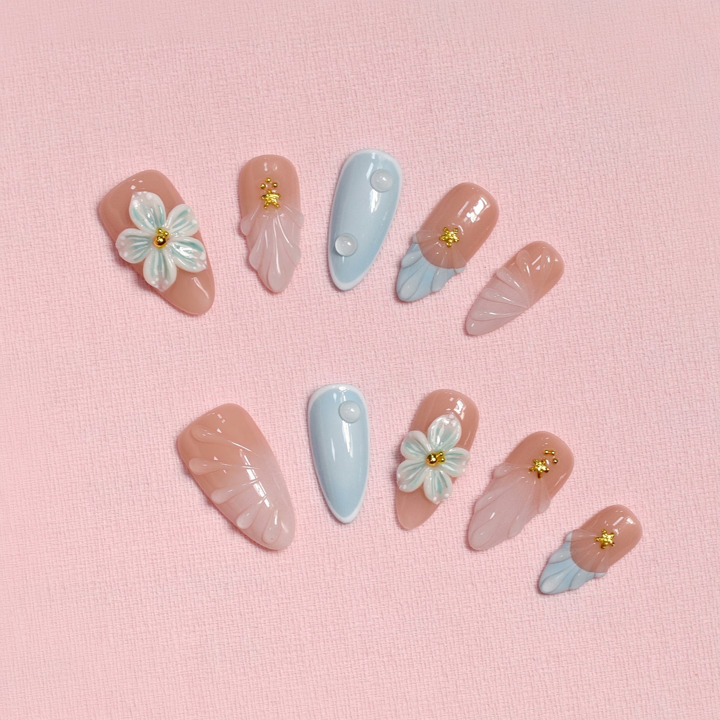 Pastel blue and pink press on nails with 3D floral accents, gold beads, and almond shape – Tropical Bloom Collection.