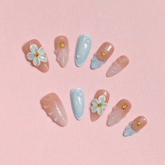 Pastel blue and pink press on nails with 3D floral accents, gold beads, and almond shape – Tropical Bloom Collection.