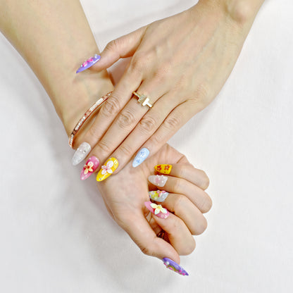 Medium almond press-on nails with bright floral 3D designs in purple, pink, yellow, and white – Petal Parade handmade nail set.