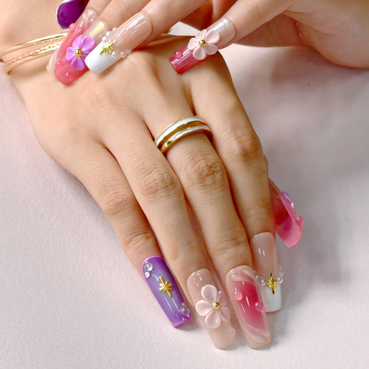 Close-up of a hand with colorful floral nail art on a light background