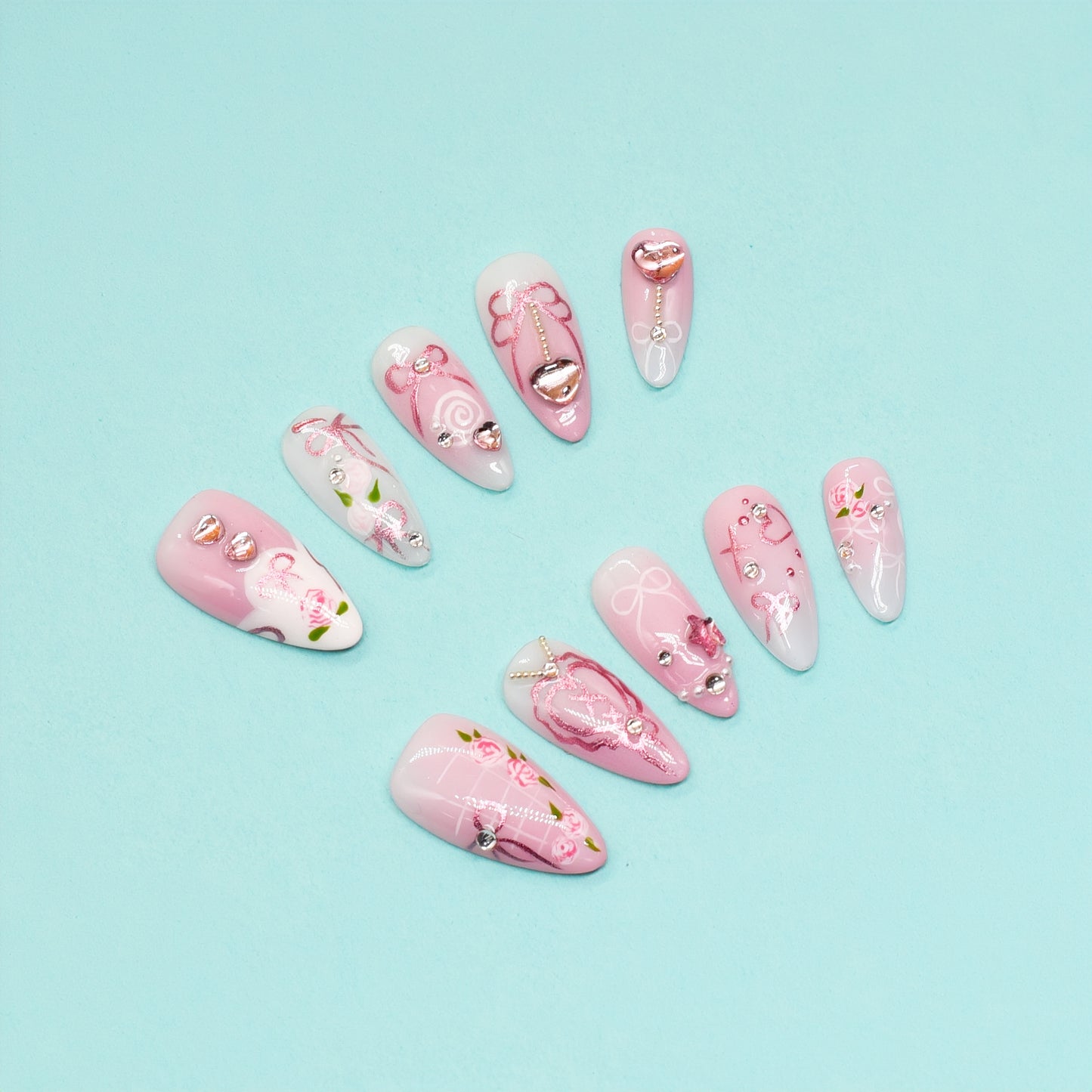 Pink press-on nails with rose art, silver heart charms, and ribbon detailing – Rosy Promise by You Are Angel.