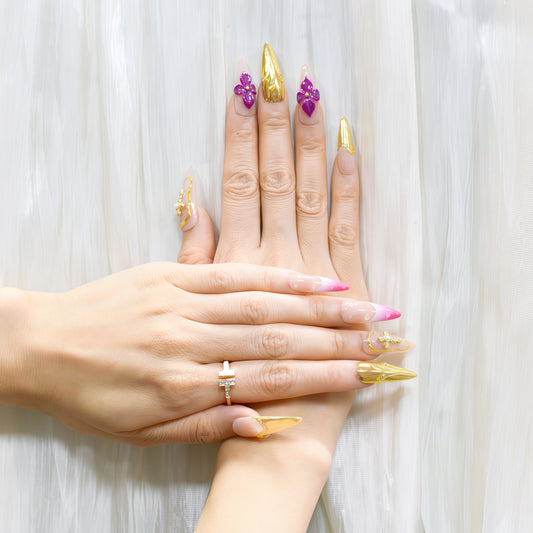 Royal Bloom press-on nails by You Are Angel with gold chrome accents, pink floral art, jeweled crosses, and long stiletto shape.