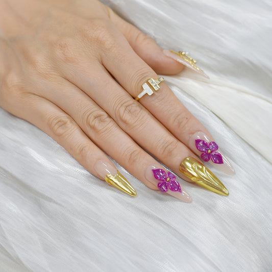 Royal Bloom press-on nails by You Are Angel with gold chrome accents, pink floral art, jeweled crosses, and long stiletto shape.