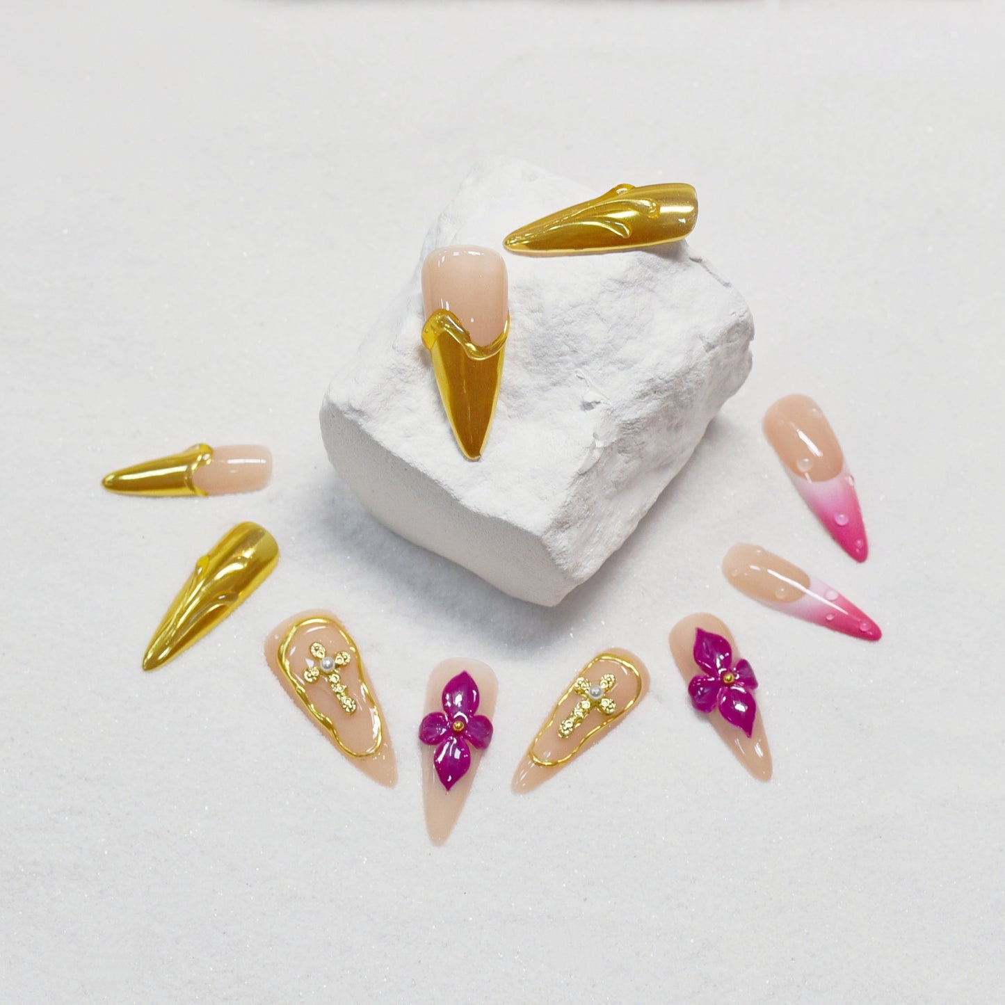 Royal Bloom press-on nails by You Are Angel with gold chrome accents, pink floral art, jeweled crosses, and long stiletto shape.