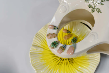 Sage green floral press on nails with gold embellishments and delicate botanical artwork.