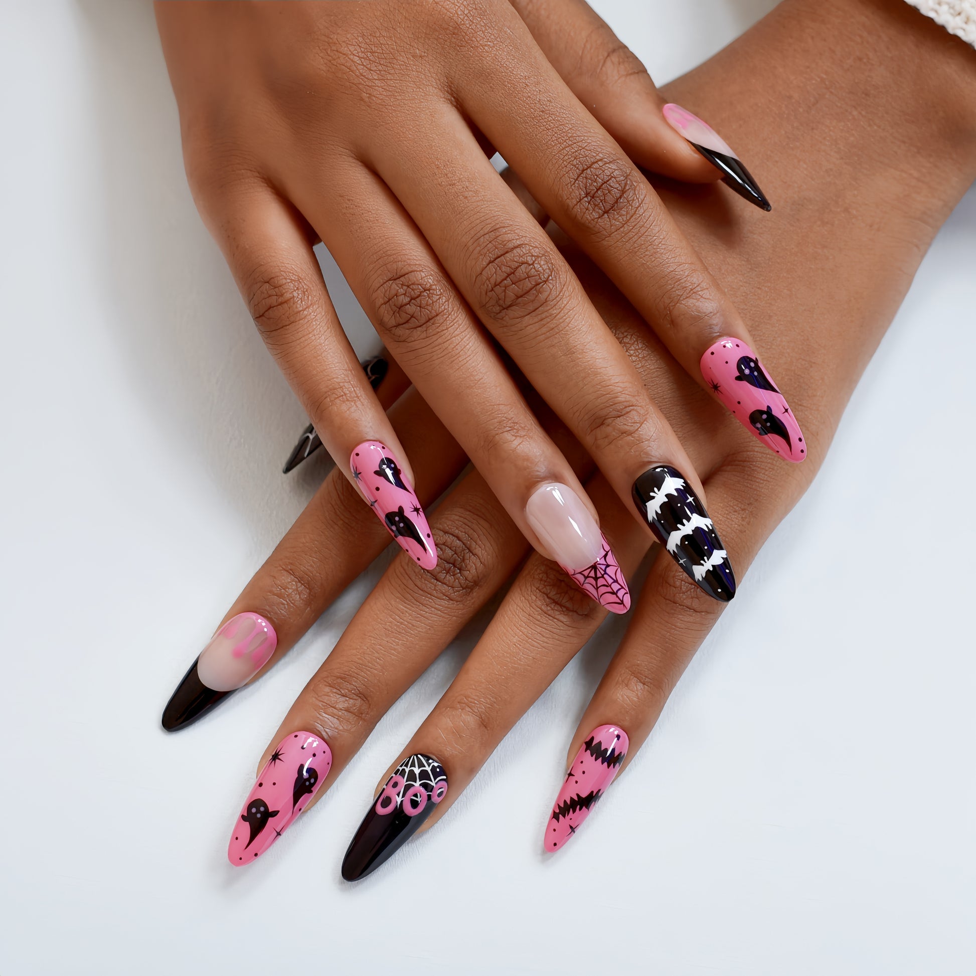 Halloween press-on nails with spider web, bats, ghosts, and dripping blood designs in black and pink.