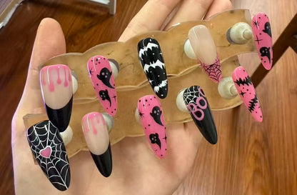 Halloween press-on nails with spider web, bats, ghosts, and dripping blood designs in black and pink.