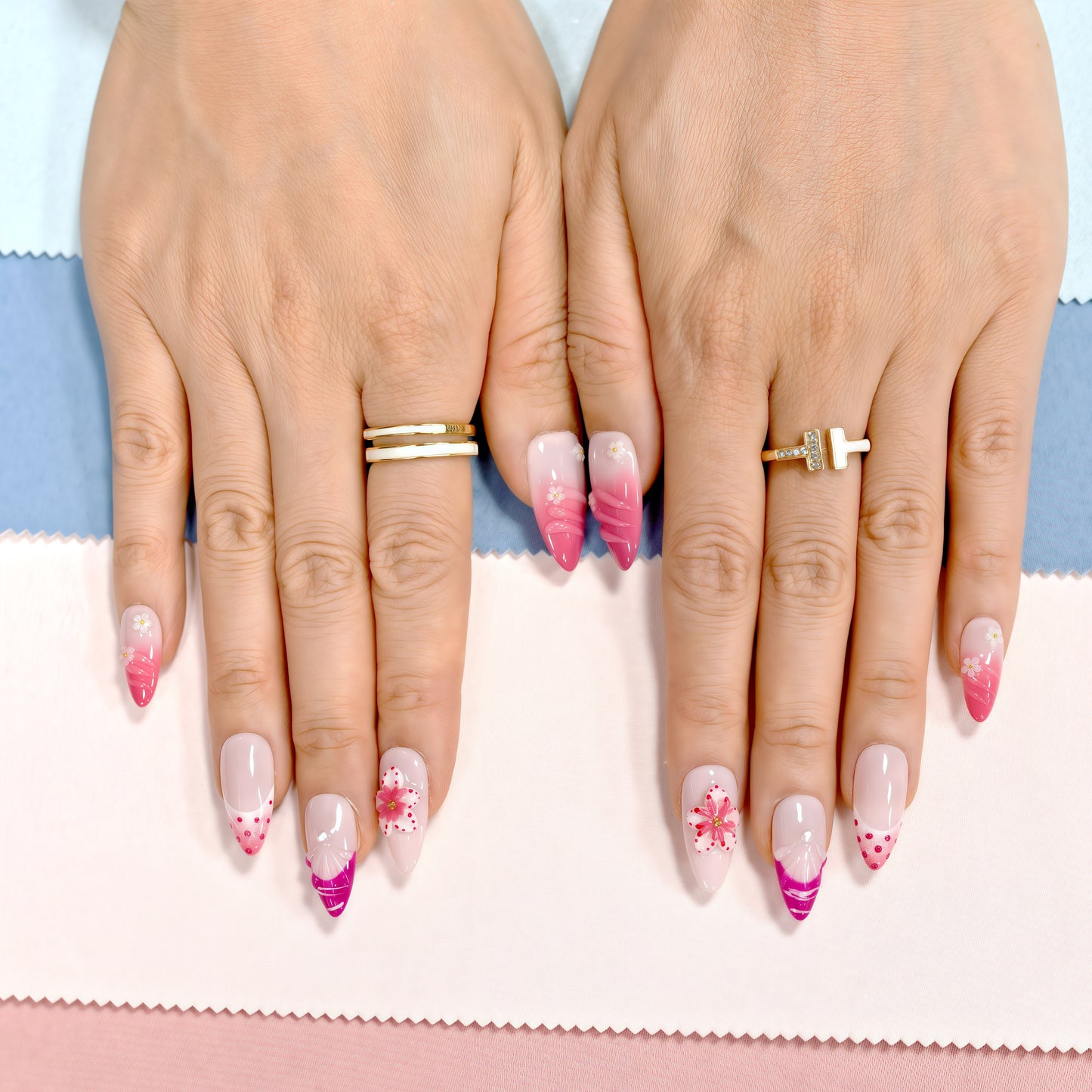 Press on nails on Close-up of hands with pink and white gradient nails on a striped background