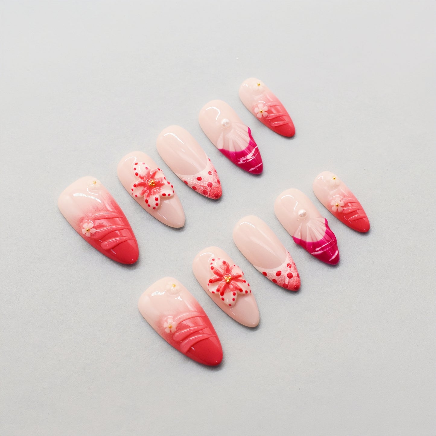 Set of nail art designs with pink and red gradient on a gray background