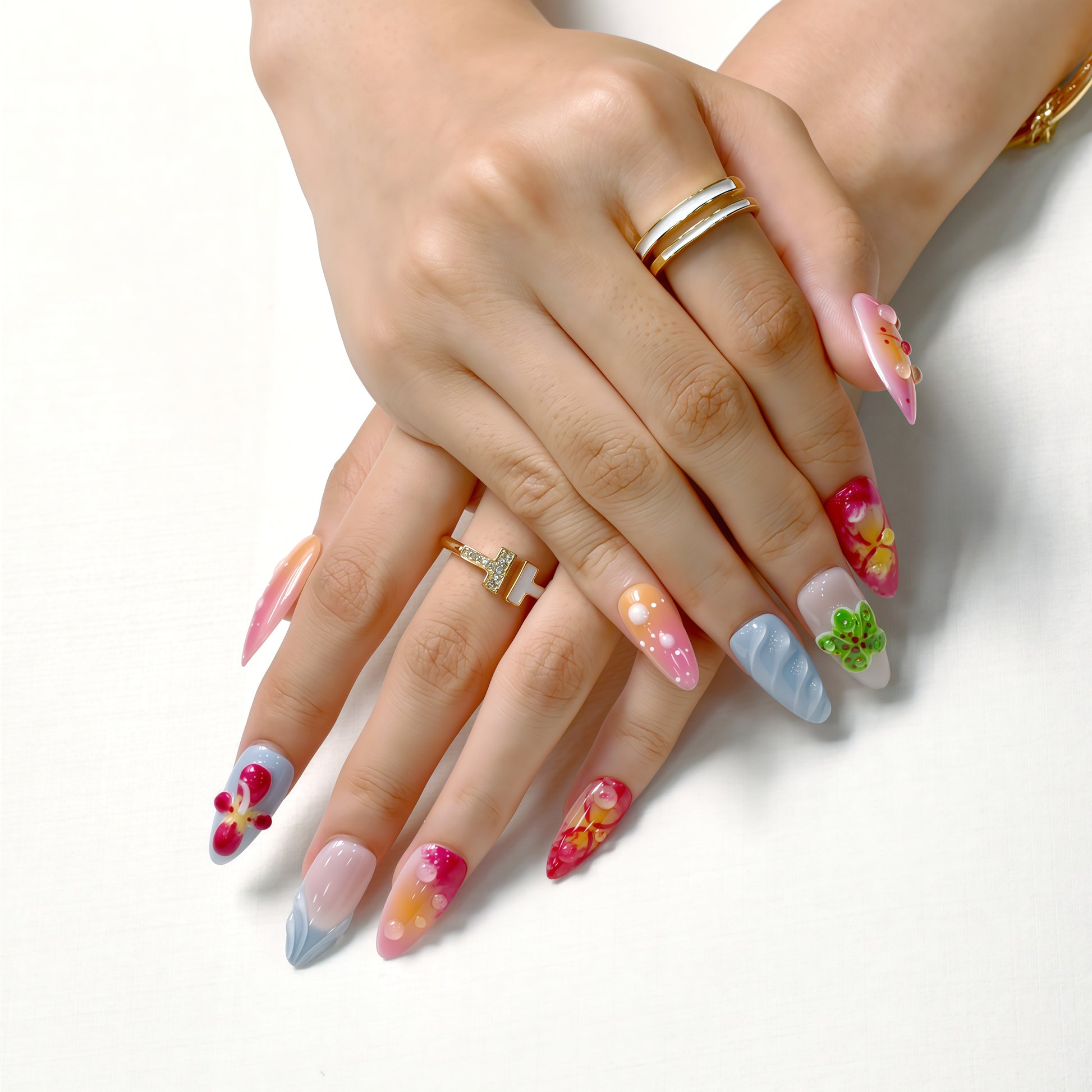 Tropical press on nails with sunset gradient, red and yellow tones, blue accents, and 3D floral charms – Tropical Bloom Collection.