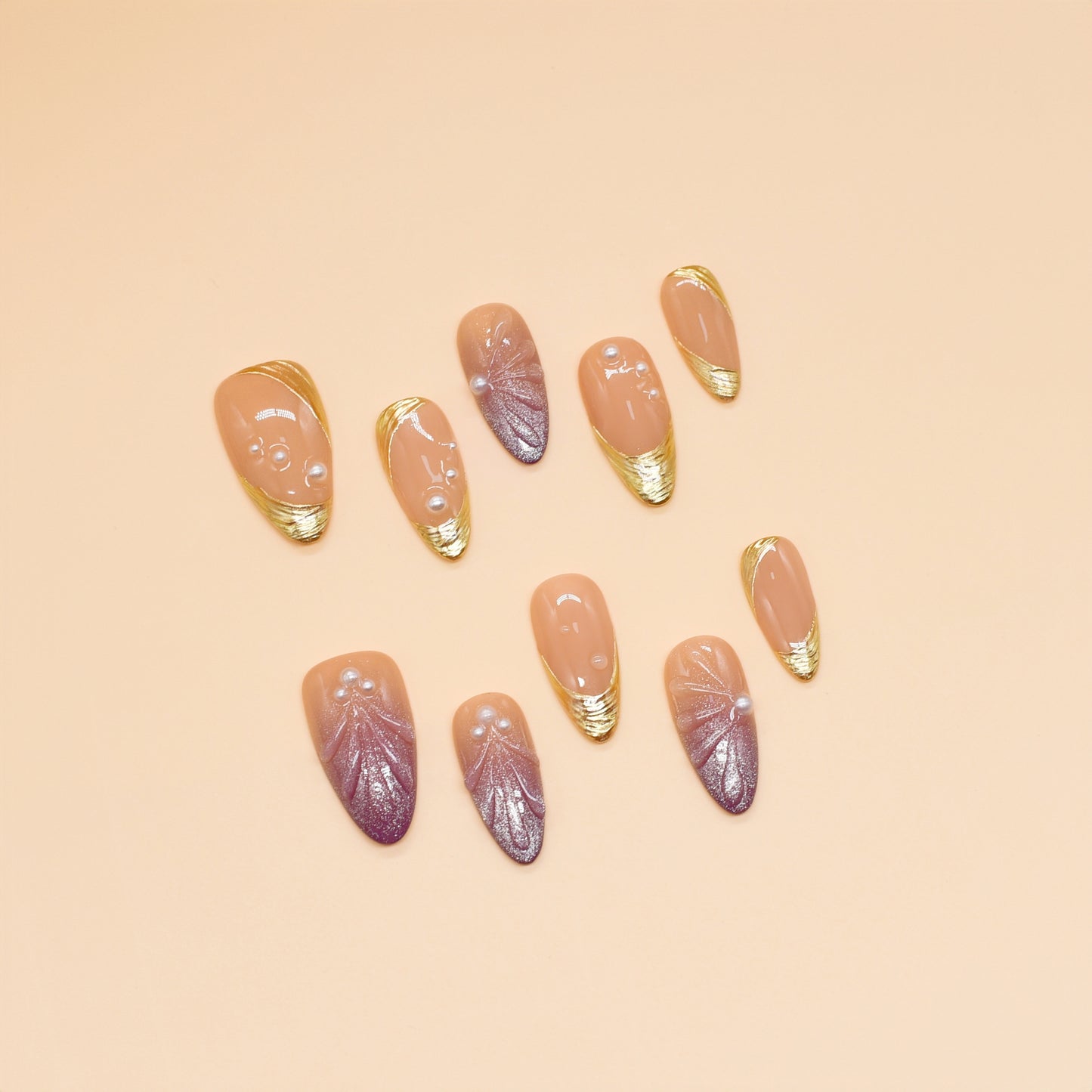Sunset Pearl Bloom press-on nails in almond shape with peach-to-mauve ombré, golden swirls, and pearl accents – Tropical Bloom Collection