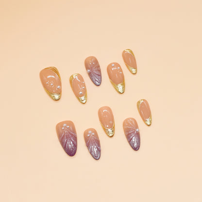 Sunset Pearl Bloom press-on nails in almond shape with peach-to-mauve ombré, golden swirls, and pearl accents – Tropical Bloom Collection