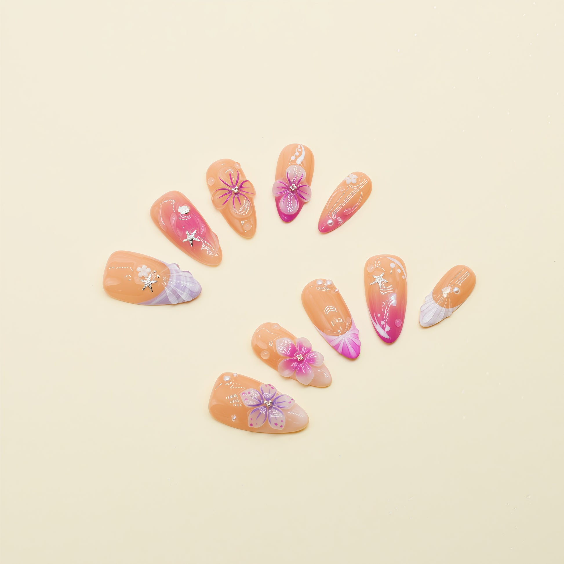 Almond-shaped coral and fuchsia press-on nails with tropical floral designs, 3D flowers, and ocean-inspired accents – Tropical Sunset Bloom set.