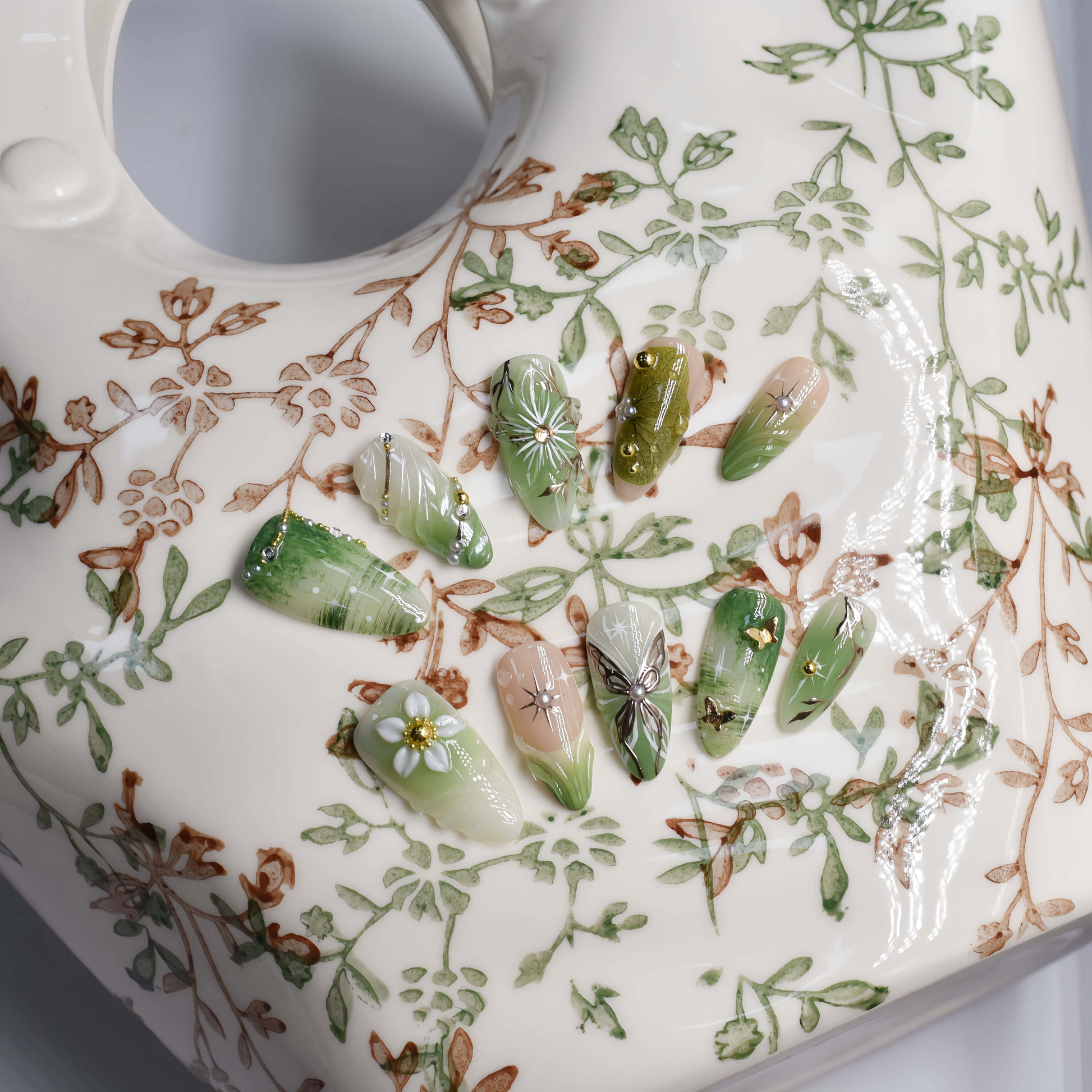 Botanical green press on nails featuring floral artwork, leaves and luxury handmade details.