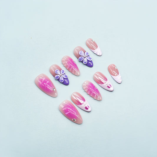 Almond-shaped press-on nails in pink-to-yellow gradient with gold beads and 3D flower accents – Sunset Bloom design.