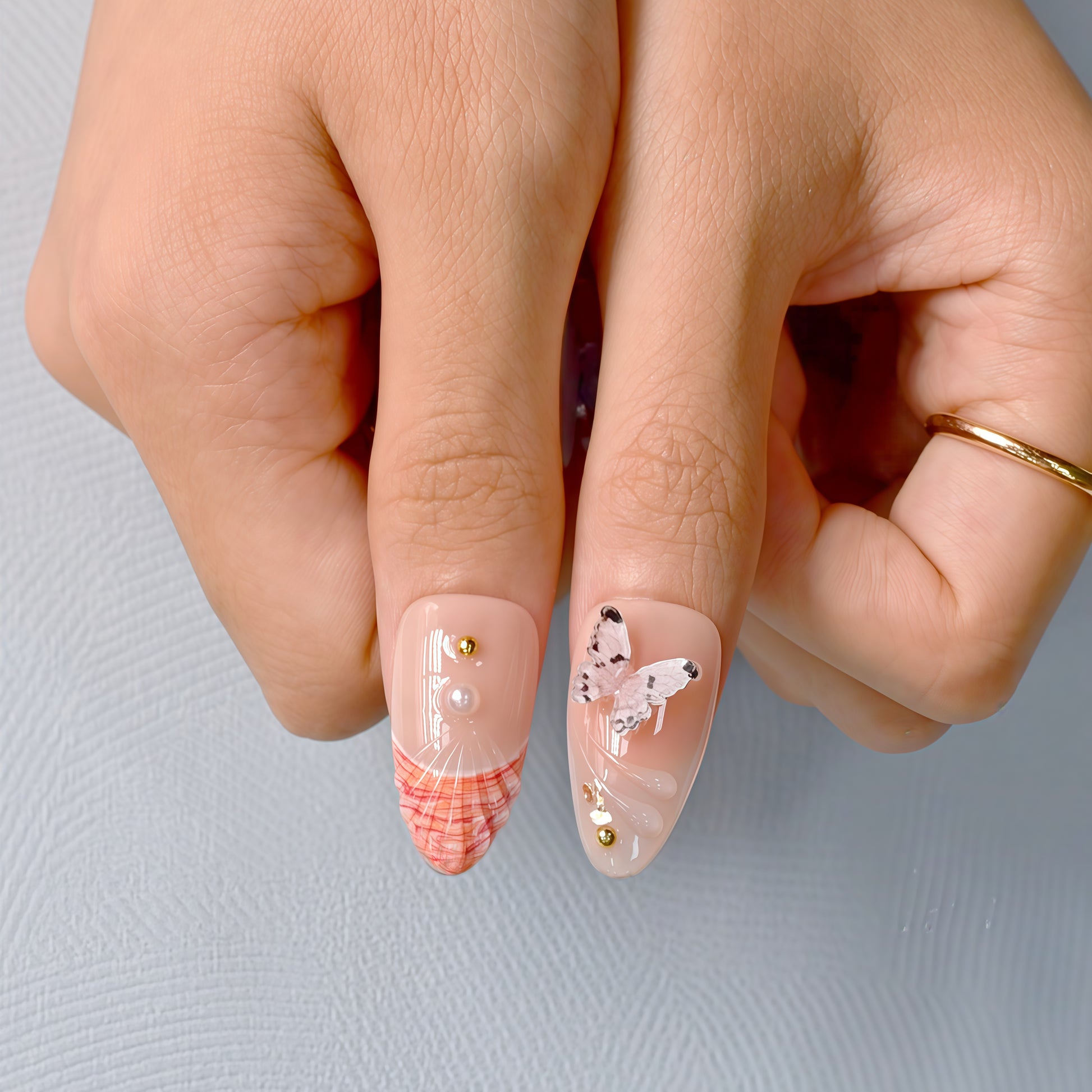 press-on nails in pastel blue, coral, nude, and white with 3D flowers, butterflies, bows, and glitter accents.