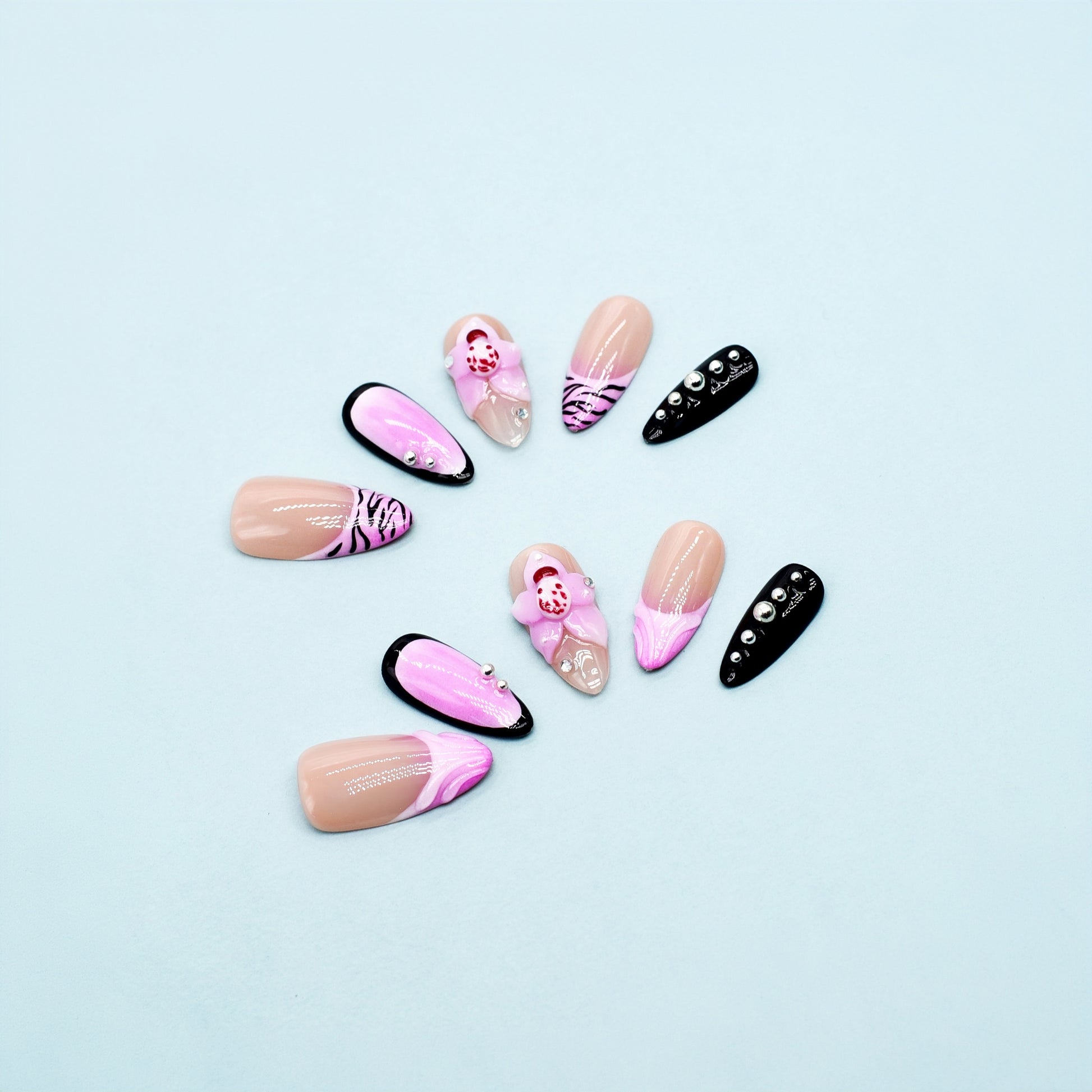 Medium Almond press-on nails in pink ombré with black zebra print, 3D orchid flowers, and rhinestone-studded accents.