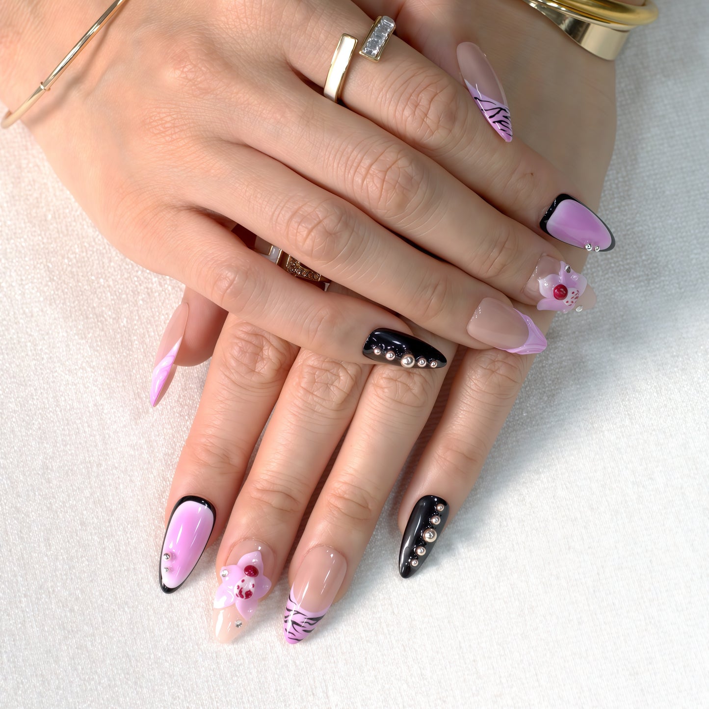 Medium Almond press-on nails in pink ombré with black zebra print, 3D orchid flowers, and rhinestone-studded accents.