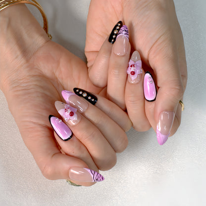 Medium Almond press-on nails in pink ombré with black zebra print, 3D orchid flowers, and rhinestone-studded accents.