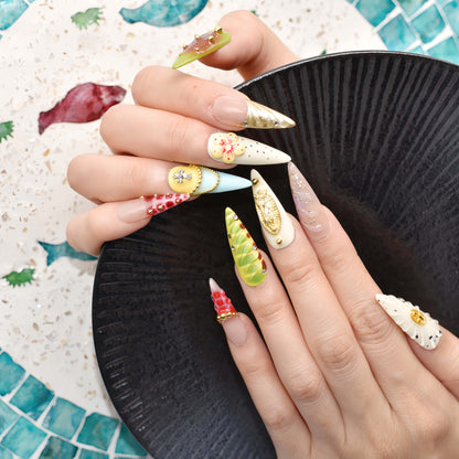 Colorful handmade fruit inspired press on nails featuring citrus slices, blueberry details and dessert inspired artwork.