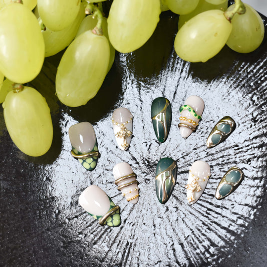 Luxury green press on nails featuring jade inspired patterns and gold metallic detailing.