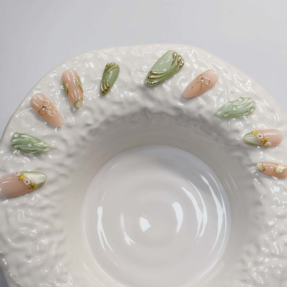 Elegant sage green and nude press on nails with gold metallic detailing and pearl accents.