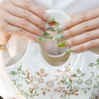 Botanical green press on nails featuring floral artwork, leaves and luxury handmade details.