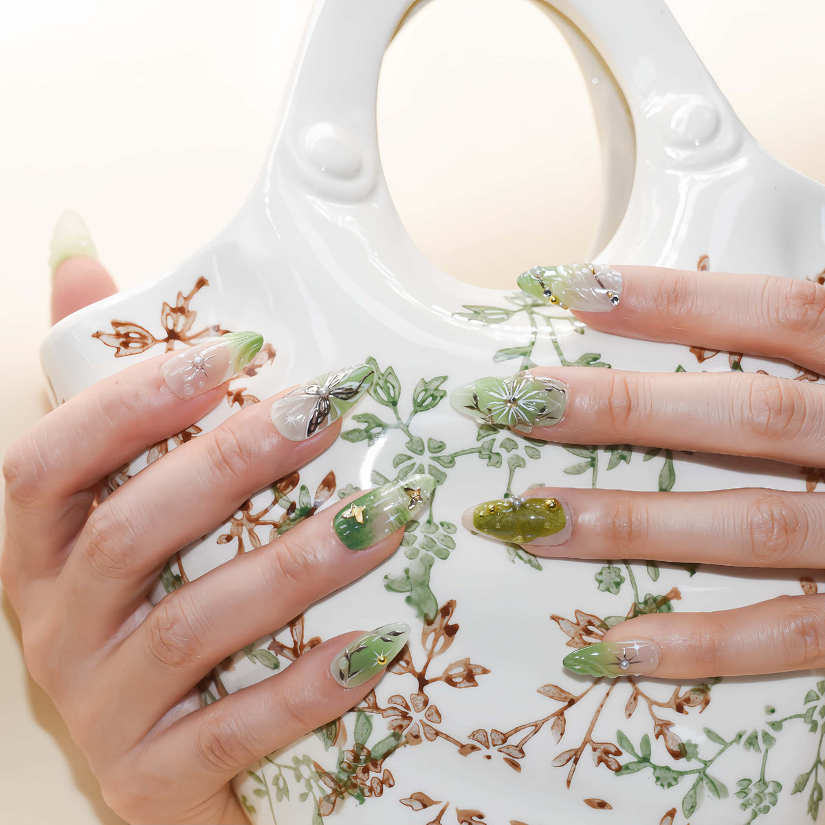 Botanical green press on nails featuring floral artwork, leaves and luxury handmade details.
