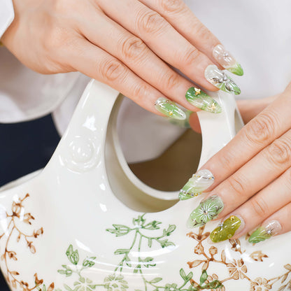 Botanical green press on nails featuring floral artwork, leaves and luxury handmade details.