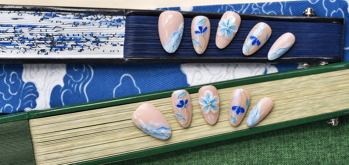 Blue Porcelain Bloom nude press-on nails with cobalt flowers, turquoise leaves and silver linework — styled product photograph.