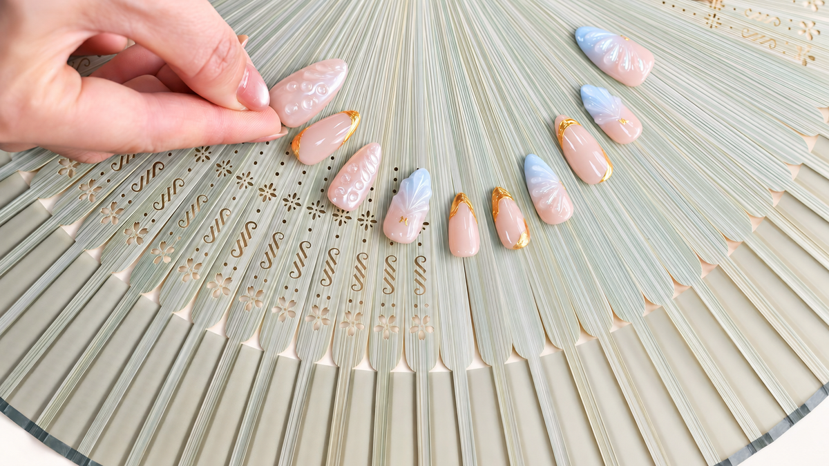 Gilded Azure Fan peach and blue press-on nails with sculpted pearl textures and gold accents — styled product photograph.